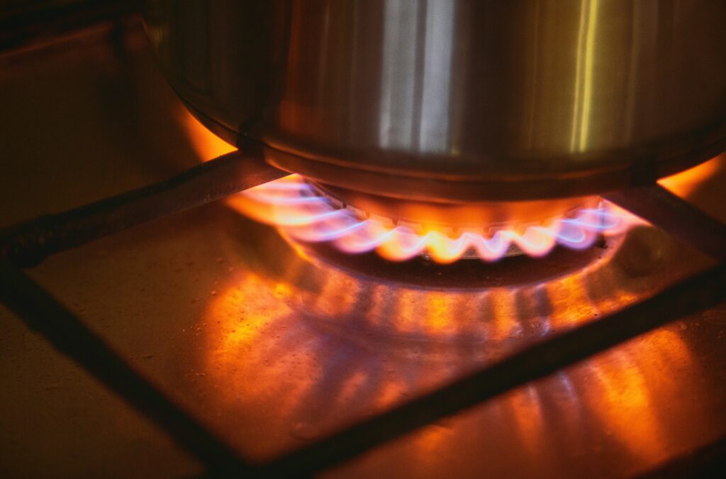 steel pot on gas stove top emitting orange flames