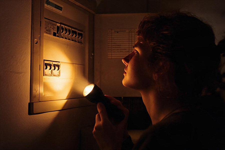 Homeowner visually checking a residential switchboard during an electrical fault